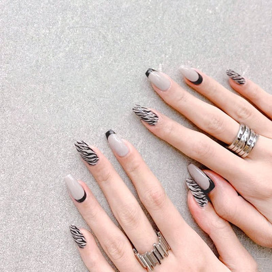Nails with zebra pattern design on a textured gray background
