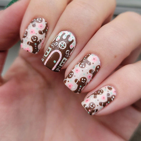 A set of nail art decals featuring a gingerbread man, short square nails, and a brown pink floral pattern.