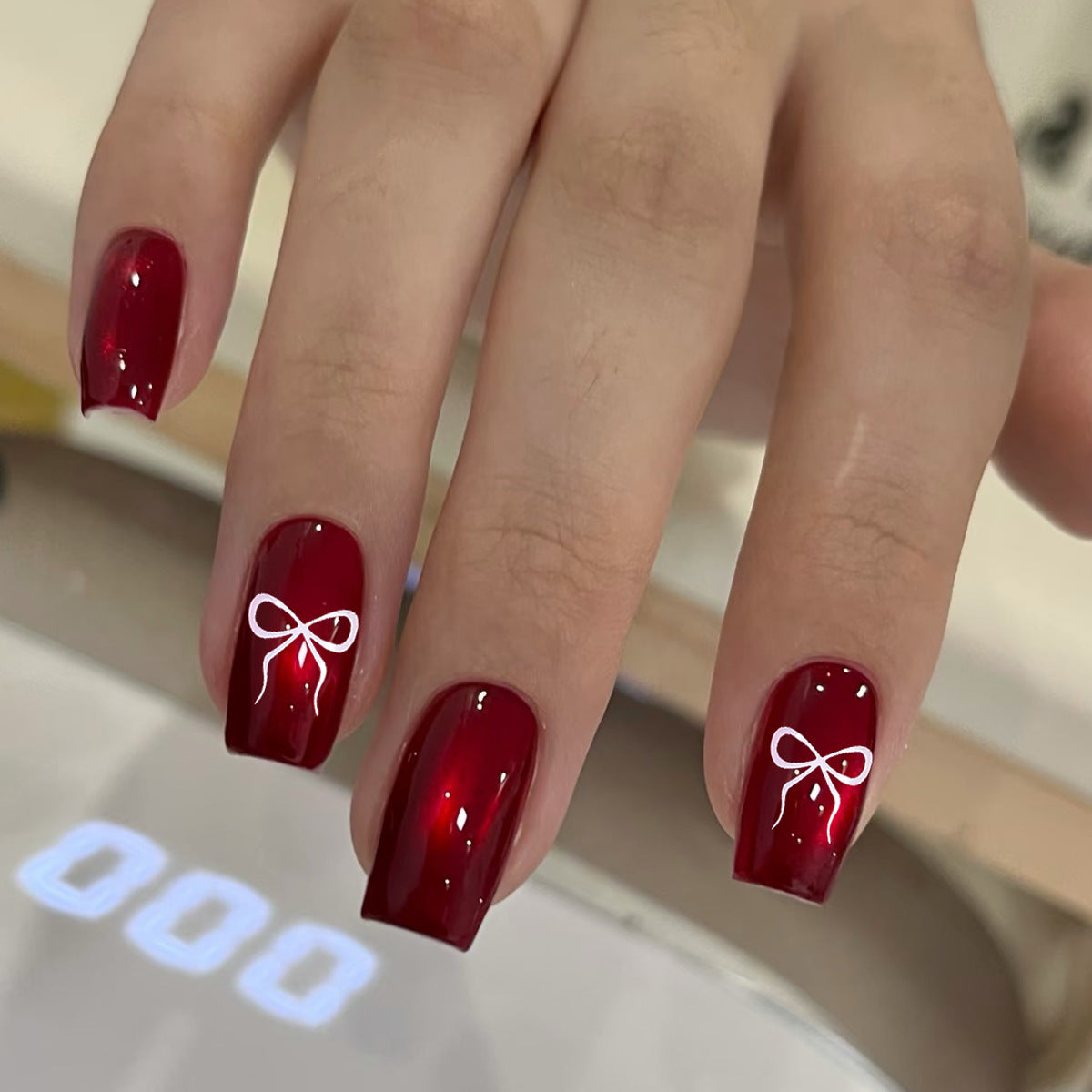 Chic Elegance Medium Square Deep Red Nails Featuring Delightful Bow Accents