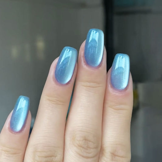 Hand with blue nail polish on a blurred background