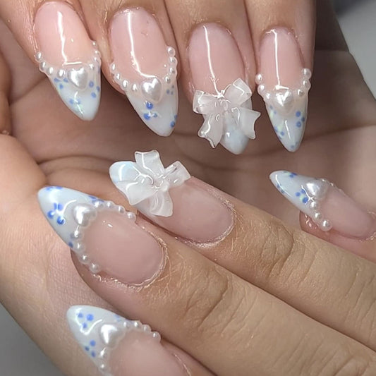Close-up of a hand with decorative nail art featuring flowers and blue accents.