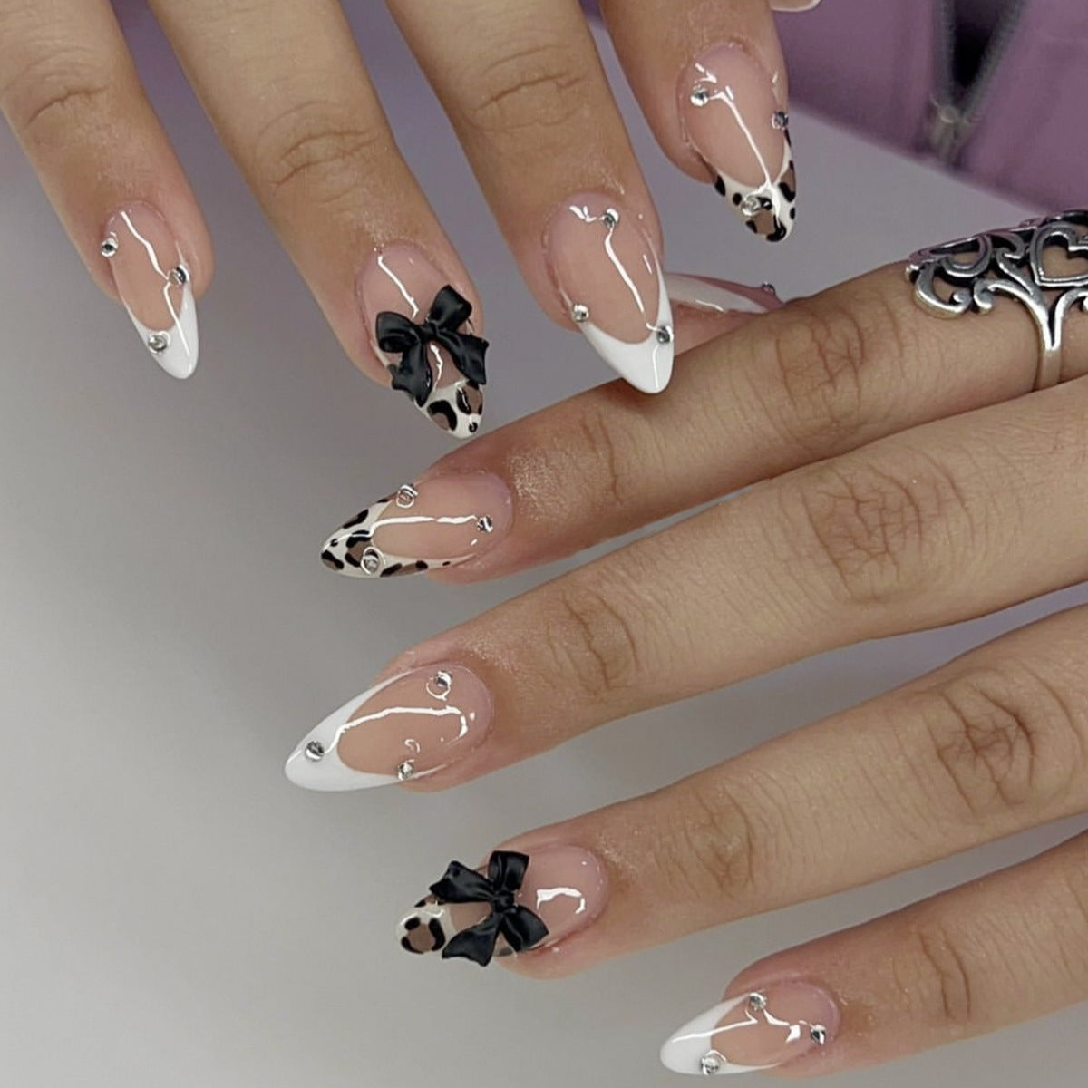 Chic Glamour Medium Almond Acrylic Nails in White and Black with Elegant Bow and Studded Accent Design