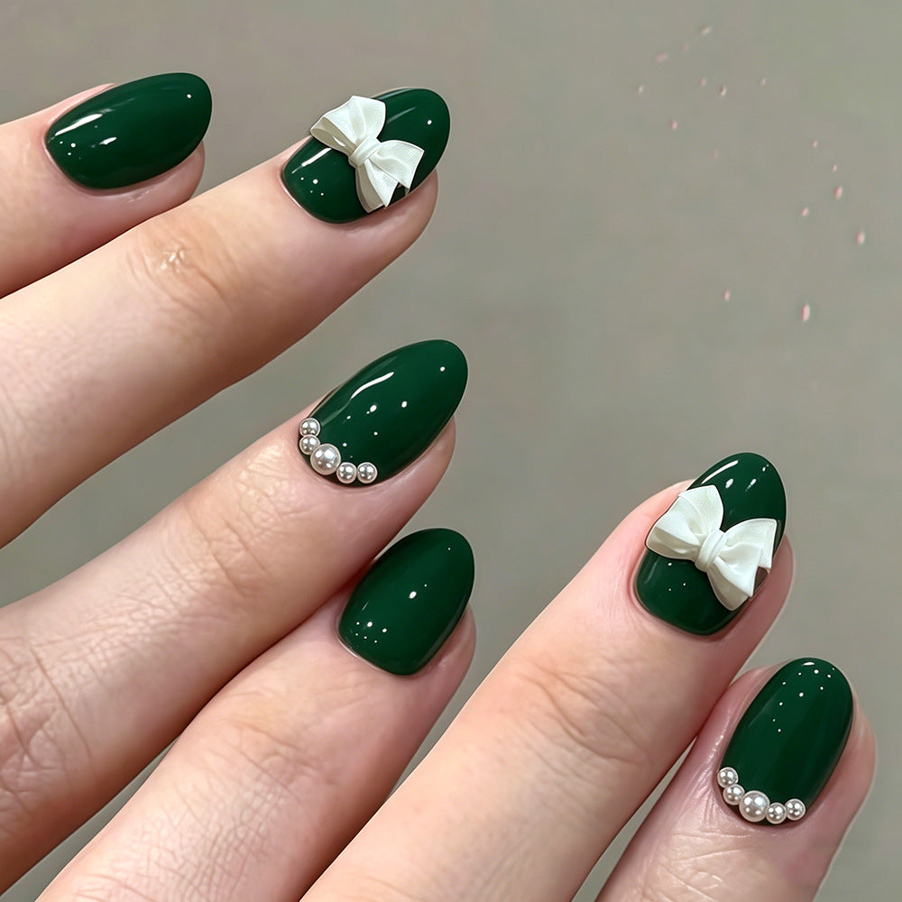 Enchanting Jewel Tone Short Oval Green Nails with Elegant Bow and Pearl Accents