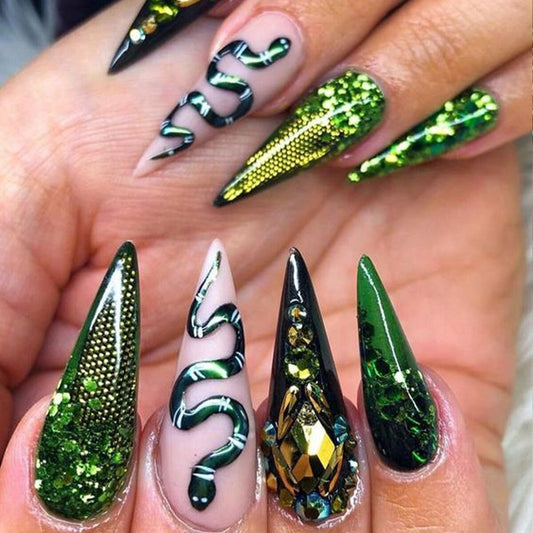 Close-up of a hand with green and black nail art on a neutral background