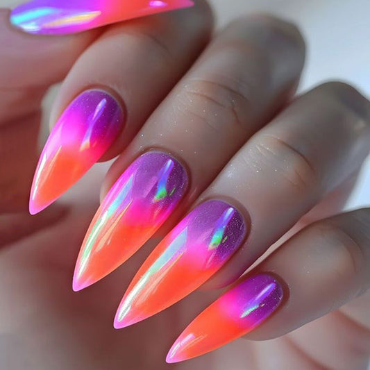 A set of press-on nails with a long, sharp ombre design in pink and orange with iridescent shine.
