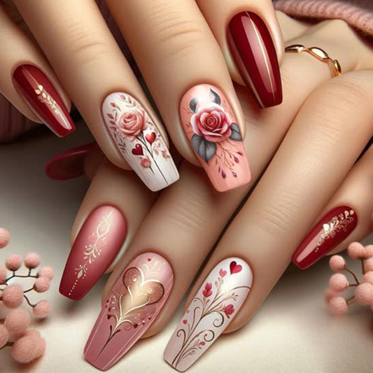 Nails with floral and heart designs in red, pink, and white on a neutral background.