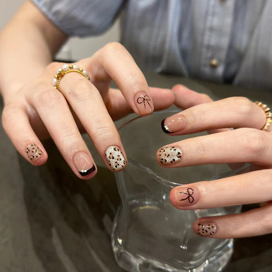 Close-up of hands with decorative nail art holding a glass.