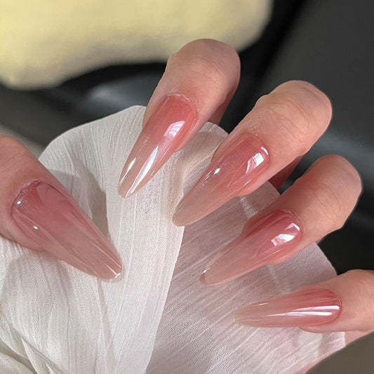 Close-up of a hand with long, pink acrylic nails on a blurred background