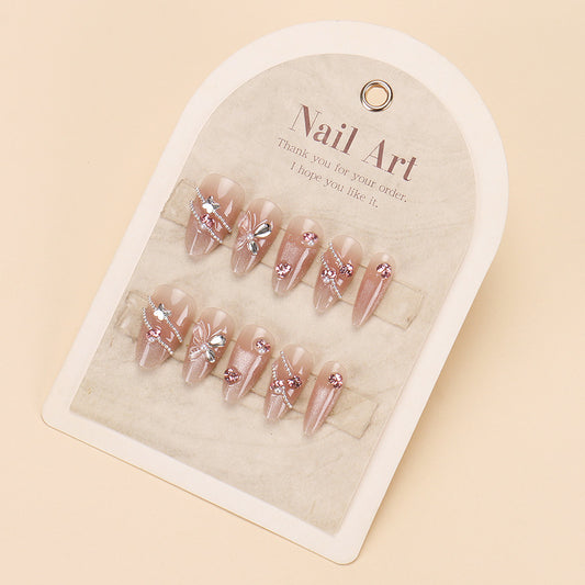 Pack of pink almond-shaped false nails with intricate floral and gemstone embellishments, displayed on a card.