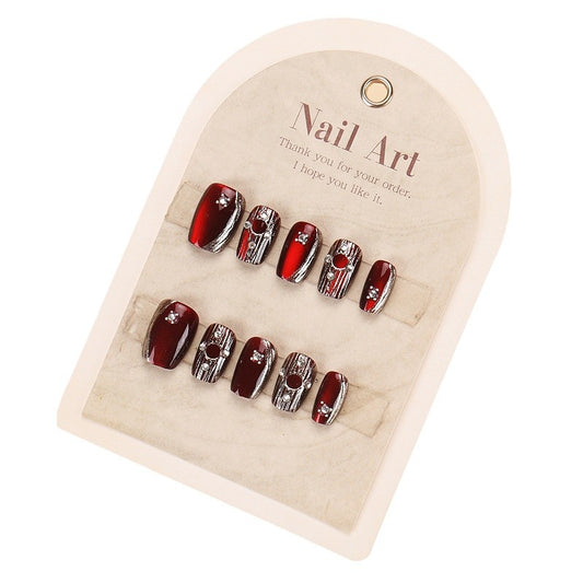 A set of false nails with a deep red color and silver accents, presented on a card with 'THANK YOU' and 'NAIL ART' printed at the top.
