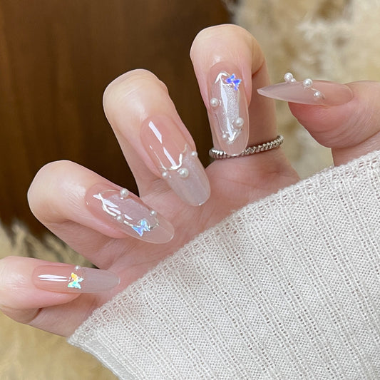 Whimsical Elegance Long Almond Crystal Clear Nails with Iridescent Butterfly Accents and Pearl Detailing