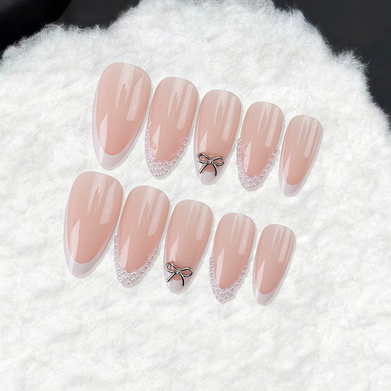 Chic Elegance Long Almond Peach Pink Nails with Dazzling Pearl and Bow Accents