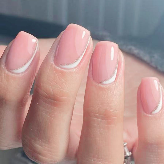 Close-up of a hand with pink nail polish on a blurred background