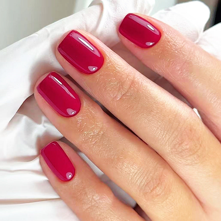 Hand with red nail polish on a white background