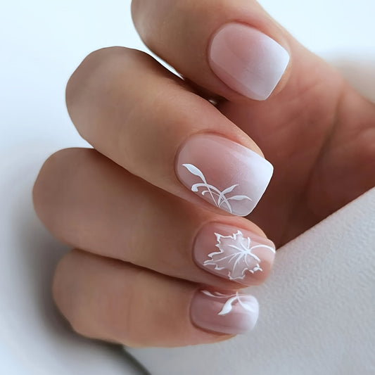 Close-up of a hand with white floral nail art on a light background