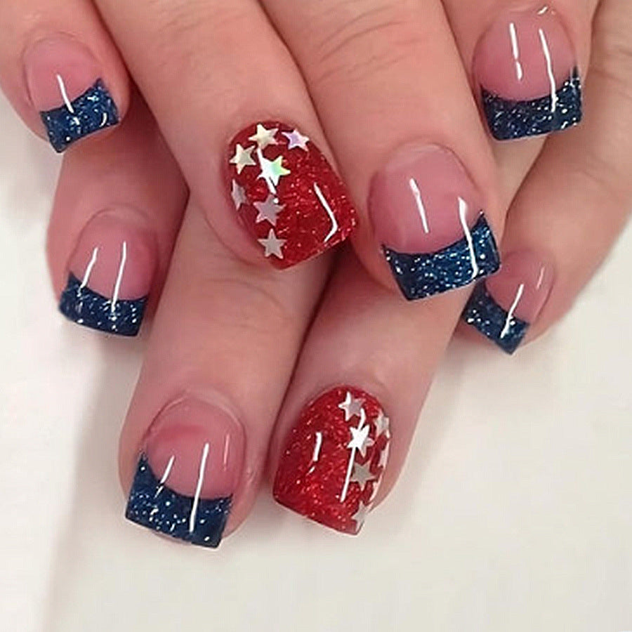 A set of press-on nails featuring a patriotic design with red, blue, and white colors, accented with glitter stars.