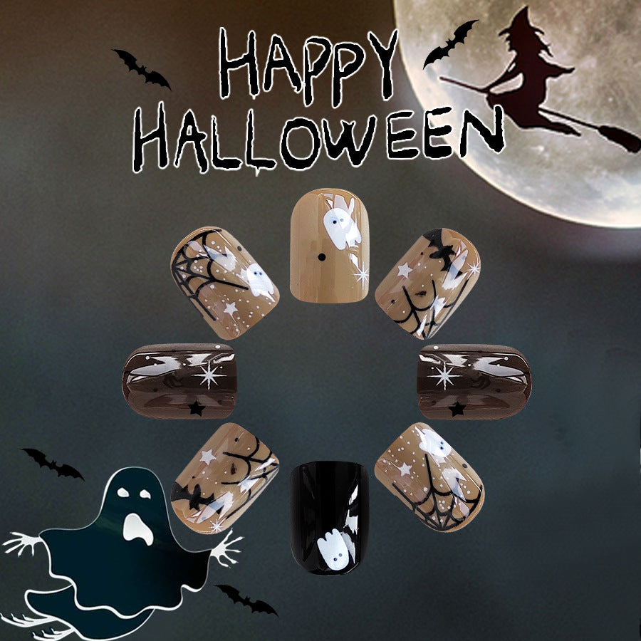 A set of press-on nails with various Halloween-themed designs including ghosts, bats, and pumpkins, predominantly in brown and black colors.