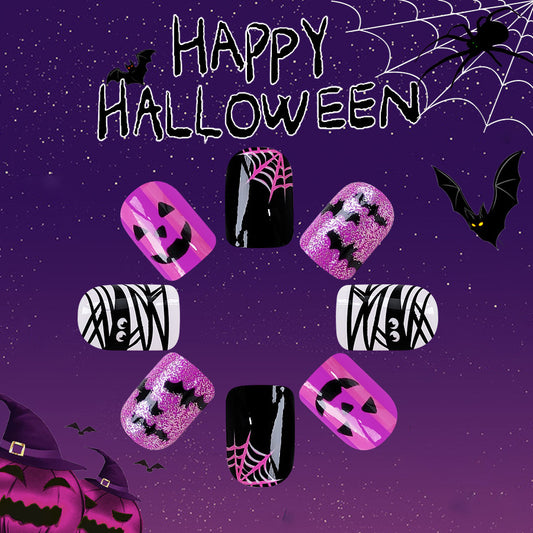 A set of press-on nails featuring a Halloween theme with black, pink, and glitter colors, and decorated with spiderweb and bat designs against a starry purple background.