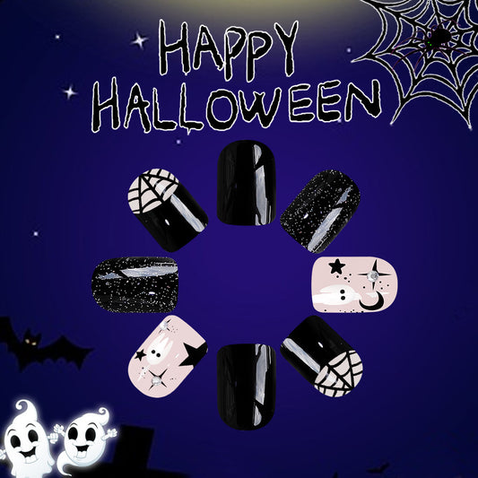 A set of short square black press-on nails with glitter accents and a playful ghost design, displayed against a Halloween-themed background with a spider web, pumpkins, and bats.