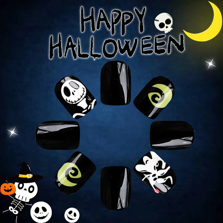 A set of black square press-on nails with various Halloween-themed designs including a skull, pumpkin, and ghosts.