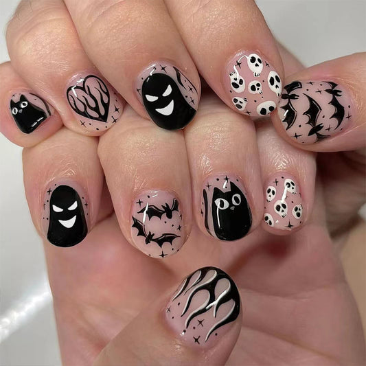 A set of press-on nails featuring a variety of Halloween-themed designs including ghosts, bats, and pumpkins in black and pink colors.