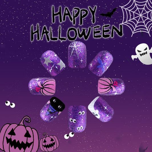 A set of purple glitter press-on nails with spooky Halloween accents, including ghosts, pumpkins, and spider webs, displayed against a starry night background.