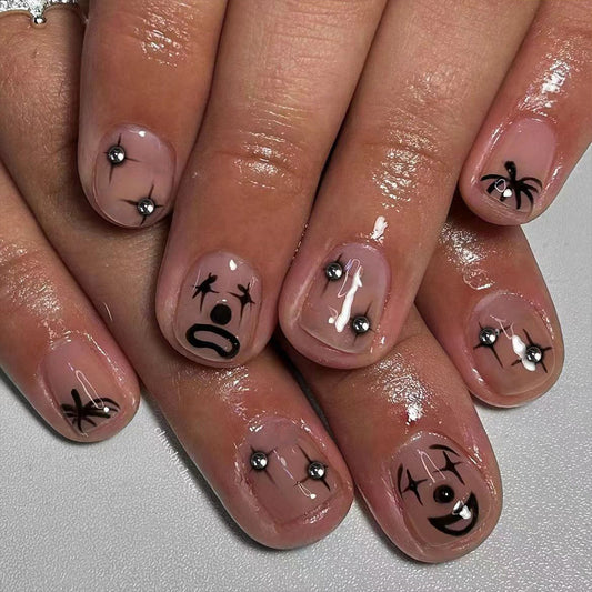 Spooky Clown Vibes Short Oval Transparent Nails with Black Graphic Designs and Rhinestone Accents