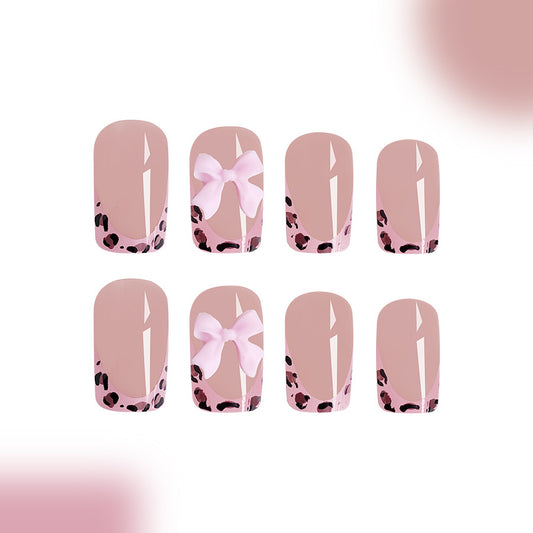 Set of nail designs with pink bows and black polka dots on a light pink background