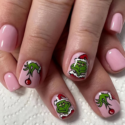 A set of press-on nails featuring whimsical grinch designs with a festive Christmas theme.