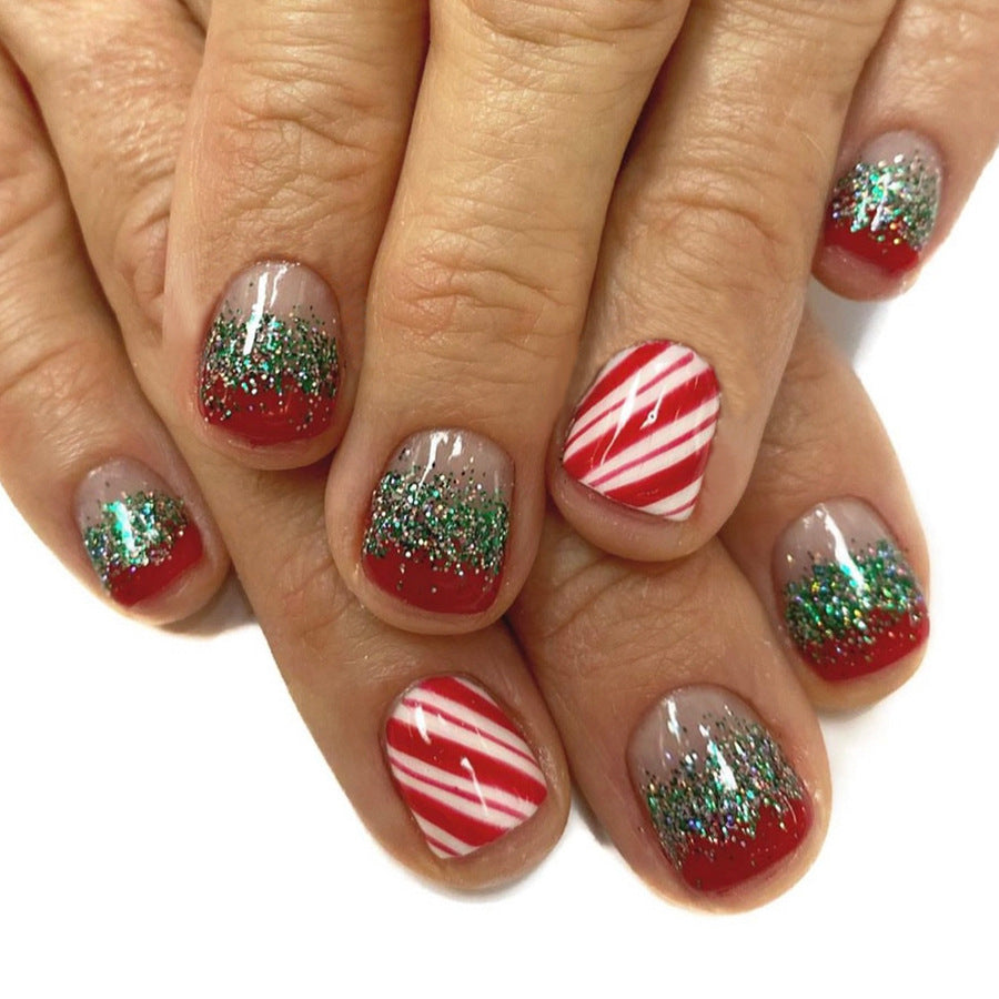 Nails with Christmas-themed design featuring red, white, and green on a white background