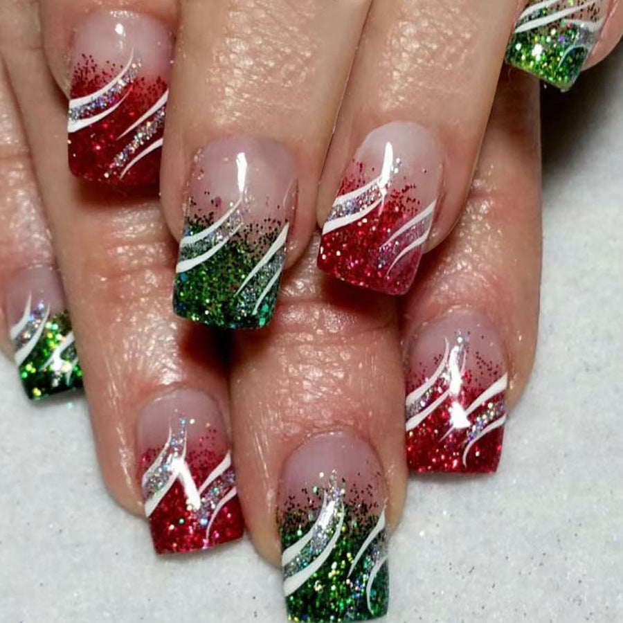 Nails with festive design featuring red, green, and white on a neutral background