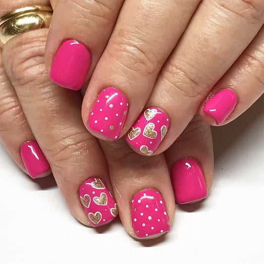 Love-themed short square pink press on nail set with gold heart accents and polka dots for a playful touch
