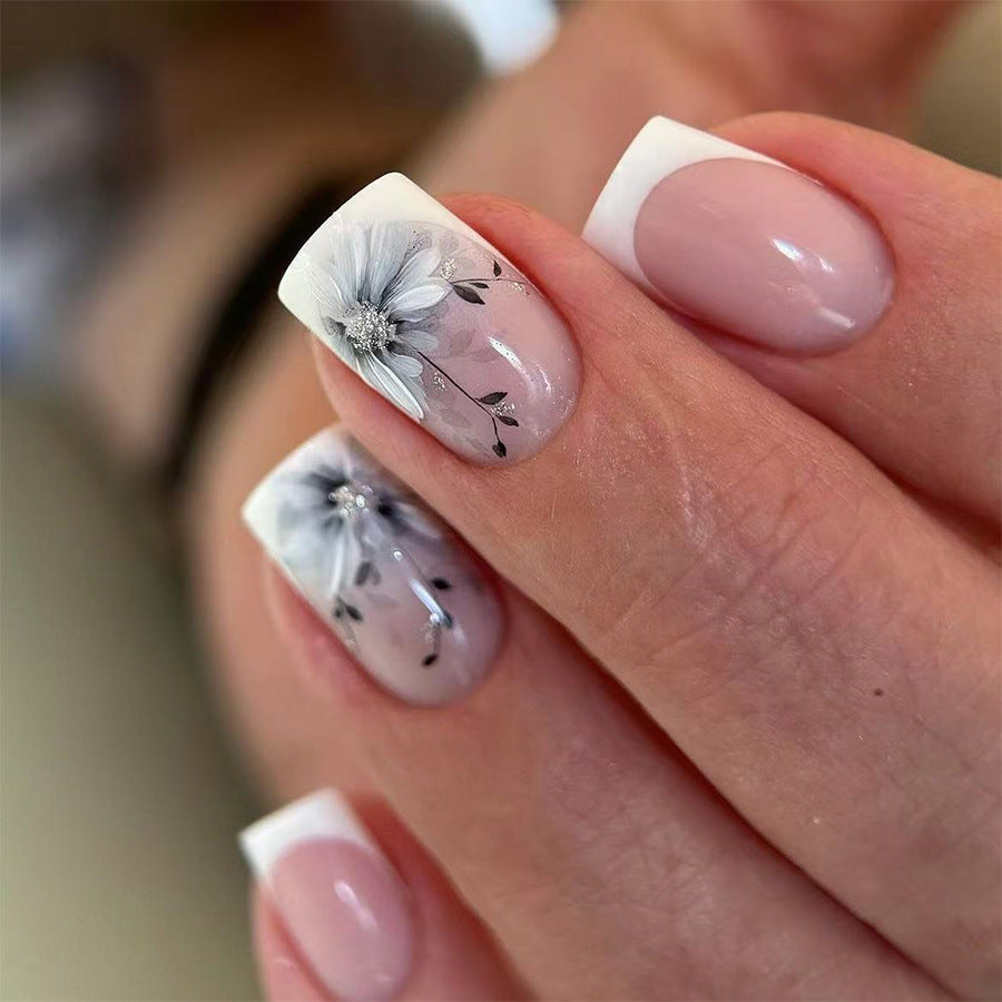 A set of short square press-on nails featuring a floral design in pink and white colors.