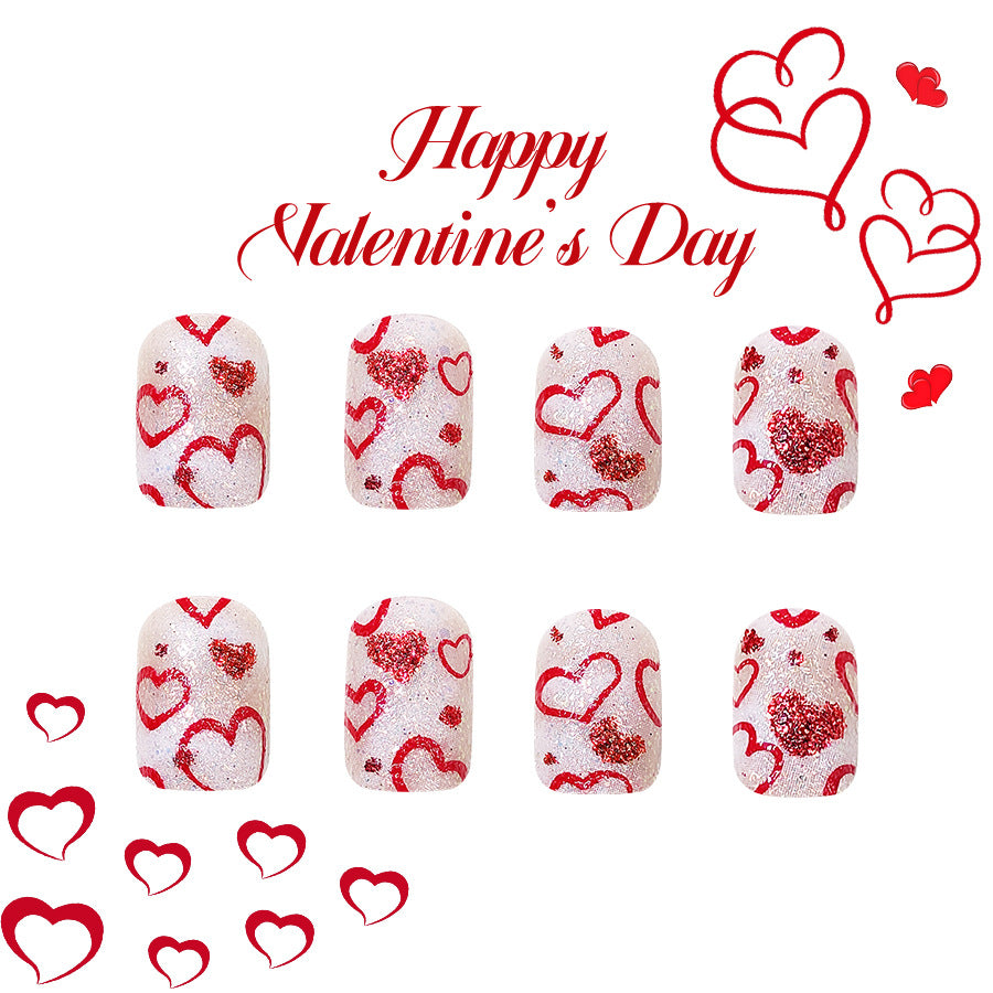 A set of press-on nails designed with a white base and red heart patterns, celebrating Valentine's Day. The image includes the text 'Happy Valentine's Day' and additional red hearts.