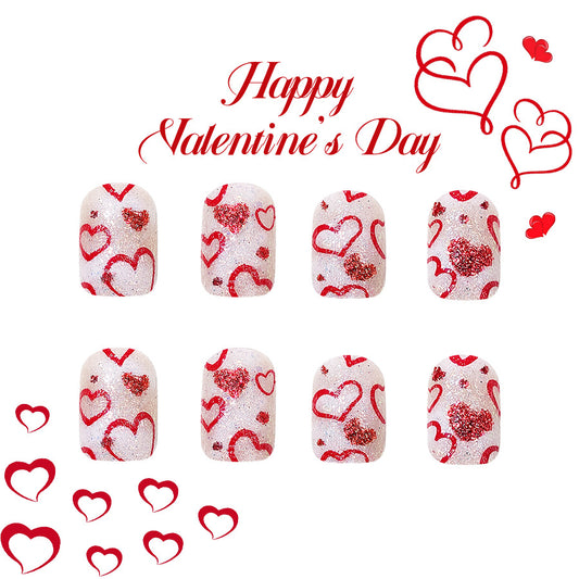 A set of press-on nails designed with a white base and red heart patterns, celebrating Valentine's Day. The image includes the text 'Happy Valentine's Day' and additional red hearts.