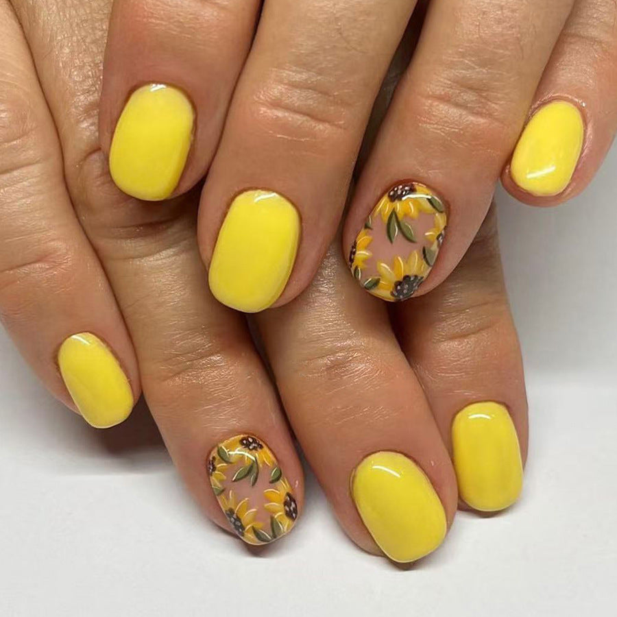 Nails with yellow polish and sunflower designs on a white background