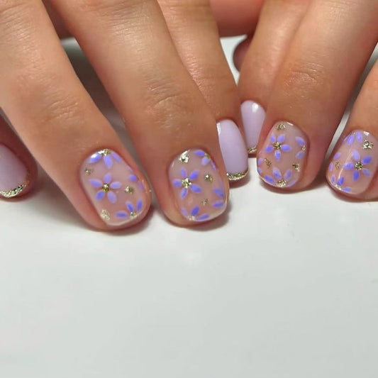Close-up of hands with floral nail design on a white background