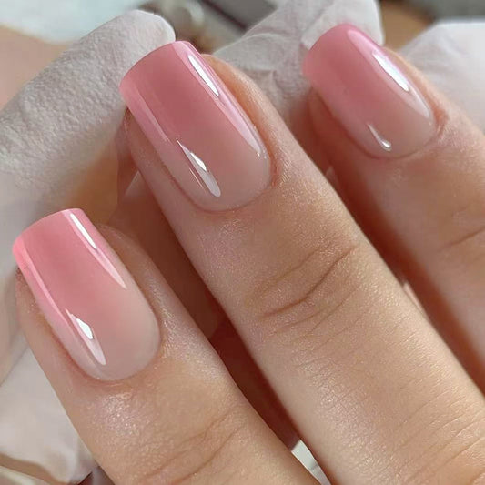 Close-up of a hand with pink nail polish on a neutral background