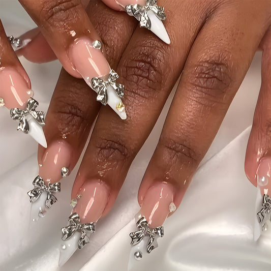 Glamorous Elegance Long Stiletto Light Pink Nails with Shiny Silver Bows and Unique Pearl Accents