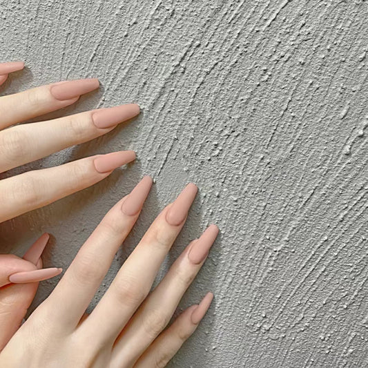 Close-up of hands with pink nail polish against a textured gray background
