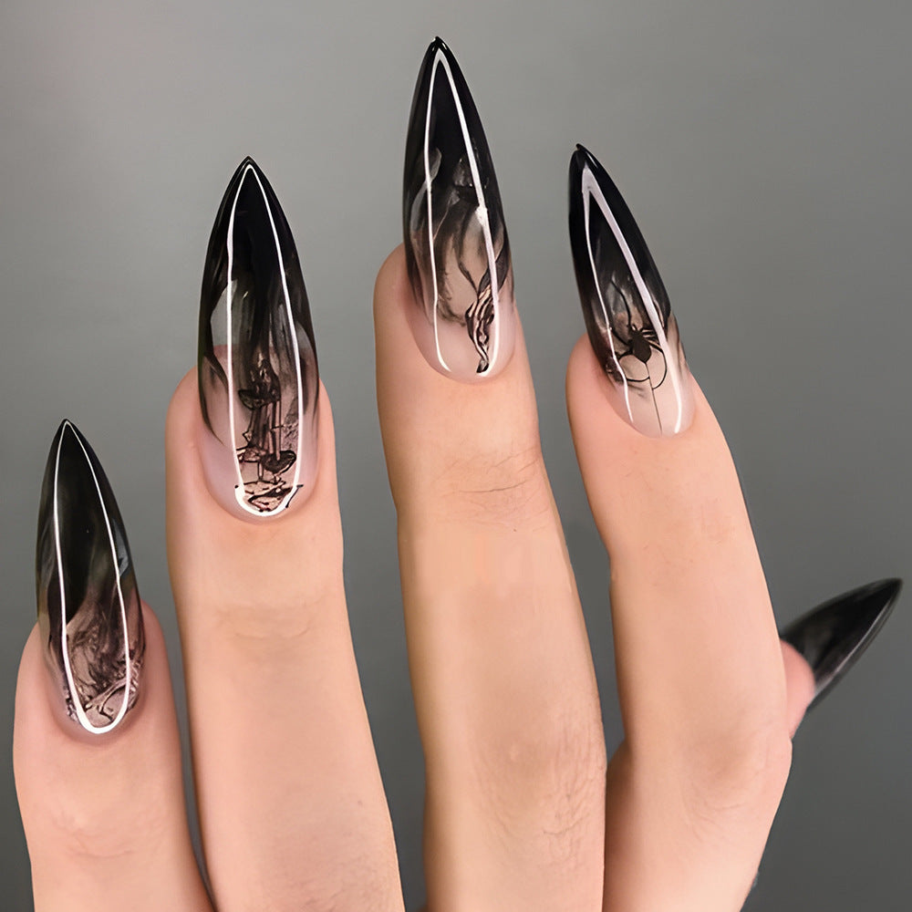 A set of long, stiletto-style black nails with an ombre design, featuring a combination of black and clear press-on nails.