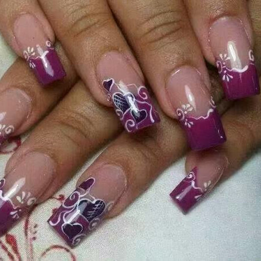 A photo showing a set of false nails with a square shape, featuring a purple tip design with floral art along the edges.