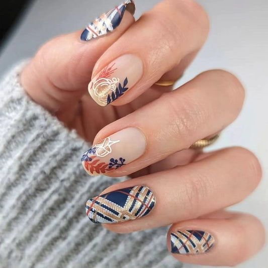 A set of press-on nails featuring a geometric and floral design in navy and beige colors.