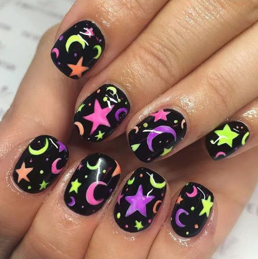 Nails with colorful star and moon designs on a black background