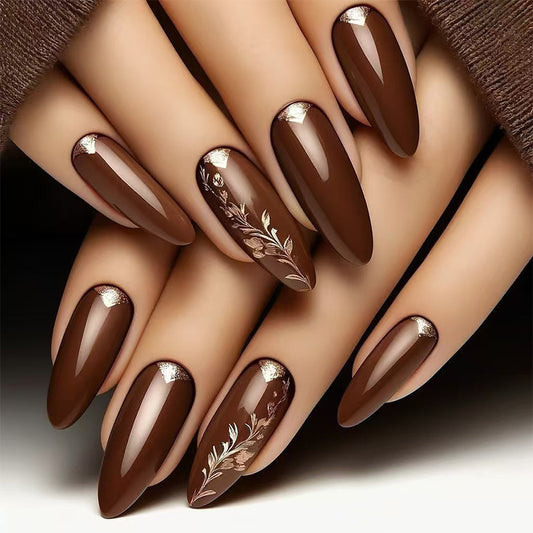 A set of press-on nails in medium almond shape, featuring a glossy brown finish with delicate floral accents on the tips.