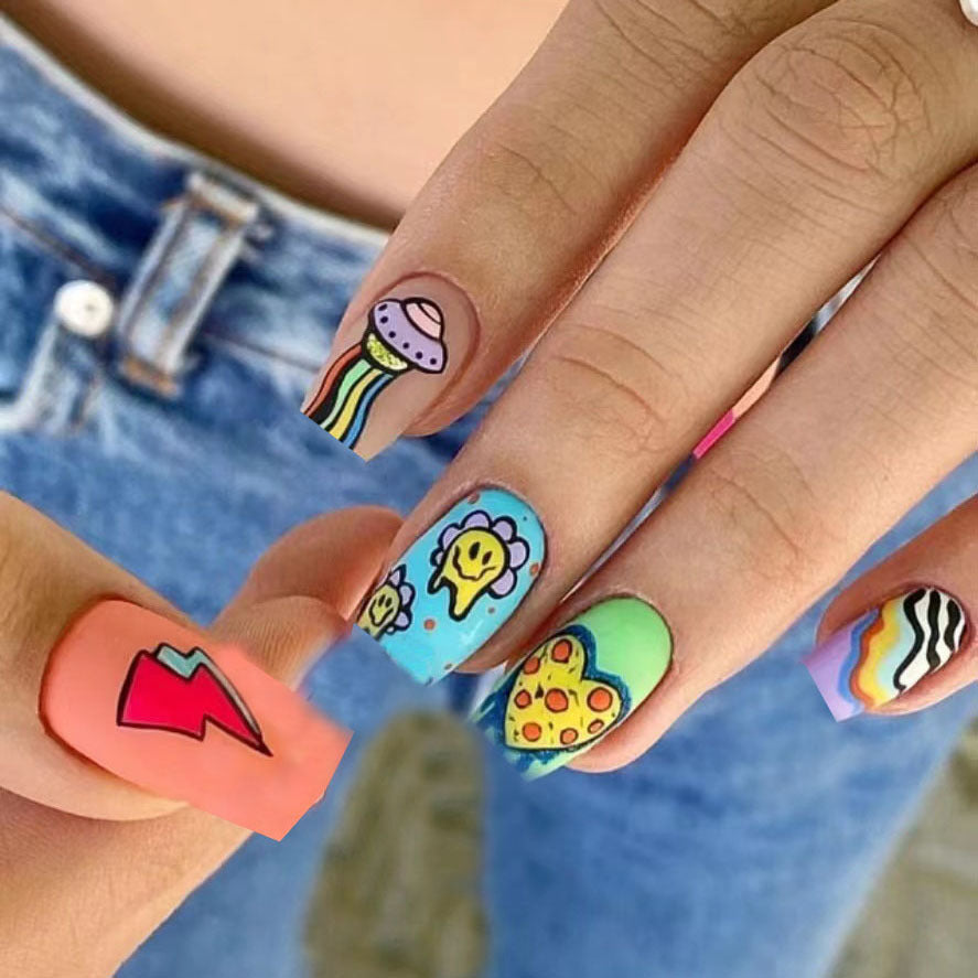 A set of colorful press-on nails featuring cartoon designs such as a cactus, flower, and other fun images.