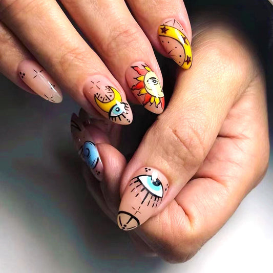 Nails with artistic designs of eyes, suns, and peace signs on a neutral background