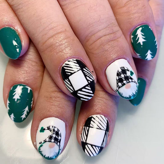 A set of holiday-themed nail art featuring a mix of green, white, and black patterns including Christmas trees and geometric shapes.
