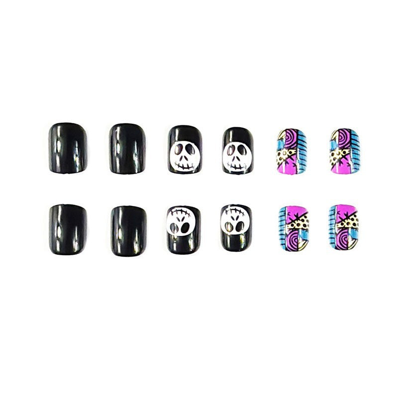 A set of false nails with a variety of Halloween-themed designs, including skulls and skeletons, primarily in black and white with some having colorful accents.