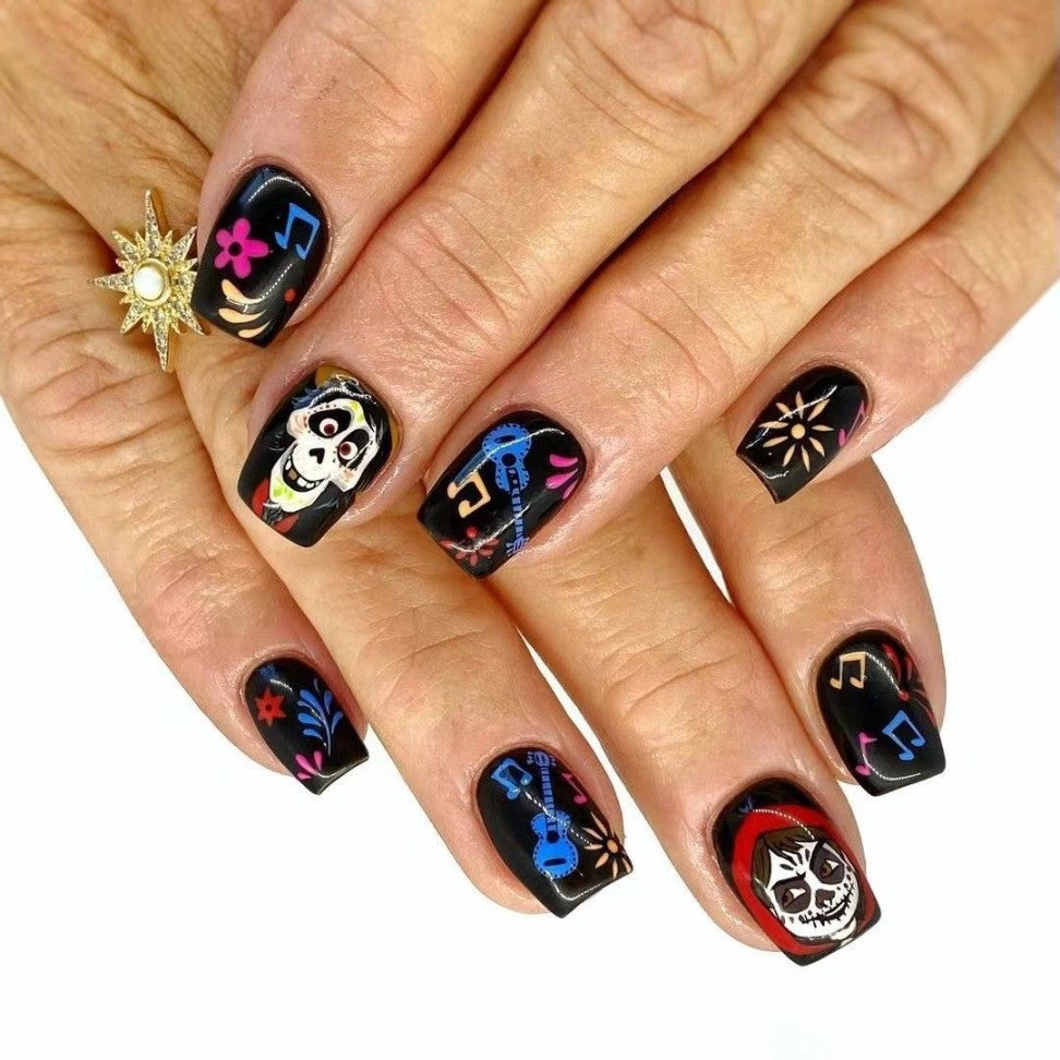 A set of black press-on nails with colorful sugar skull designs and musical notes.